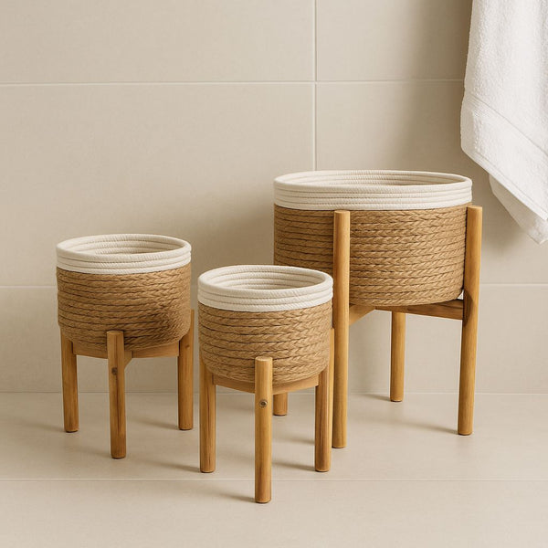 Three woven baskets with wooden legs on a neutral background