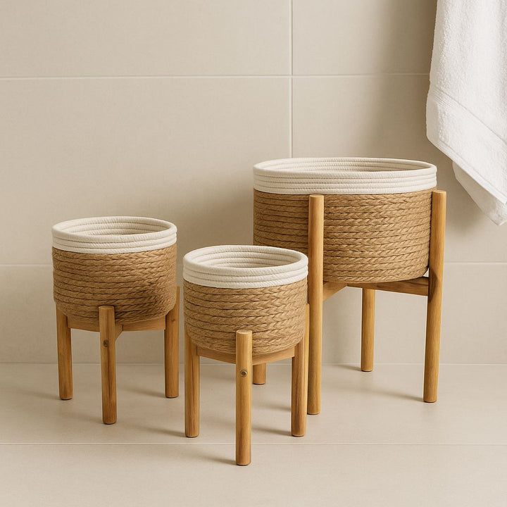 Three woven baskets with wooden legs on a neutral background
