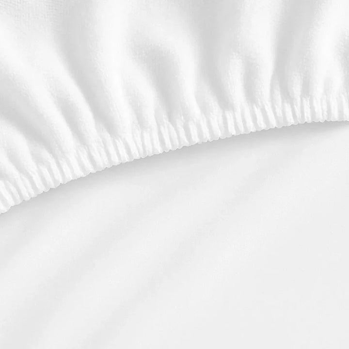 Close-up of a waterproof cotton mattress protector with visible elastic edging and smooth fabric surface