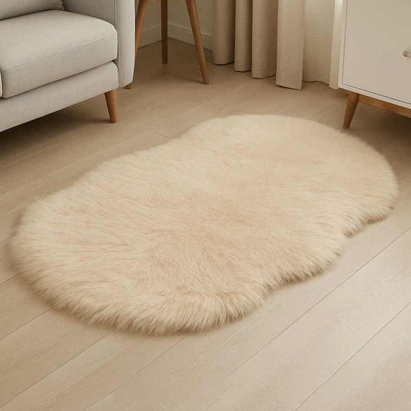 Beige oval rug on a wooden floor with a neutral-colored sofa and curtains in the background.