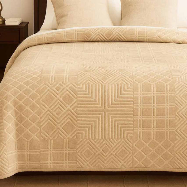 Beige winter blanket with geometric pattern on a bed