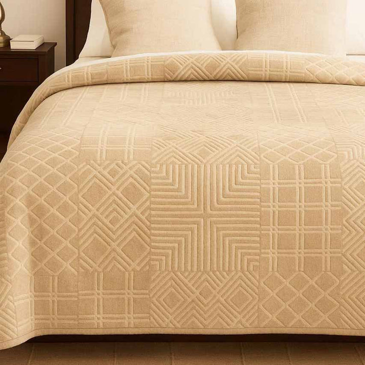 Beige winter blanket with geometric pattern on a bed