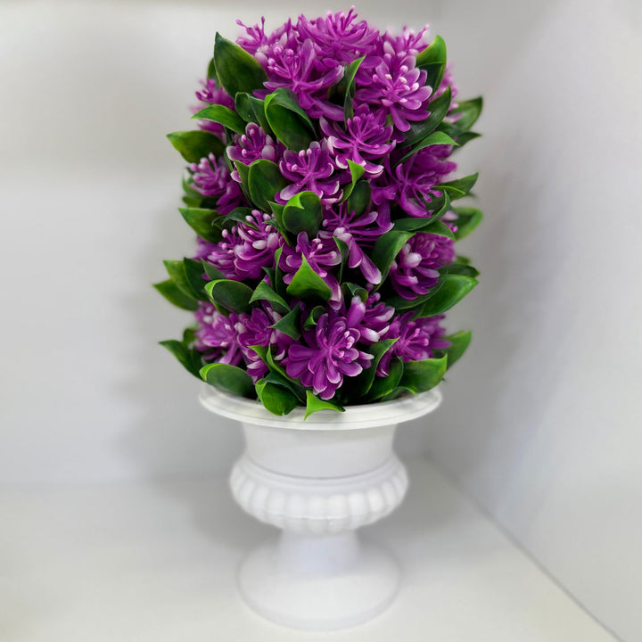Purple flowers in a white vase on a light gray background