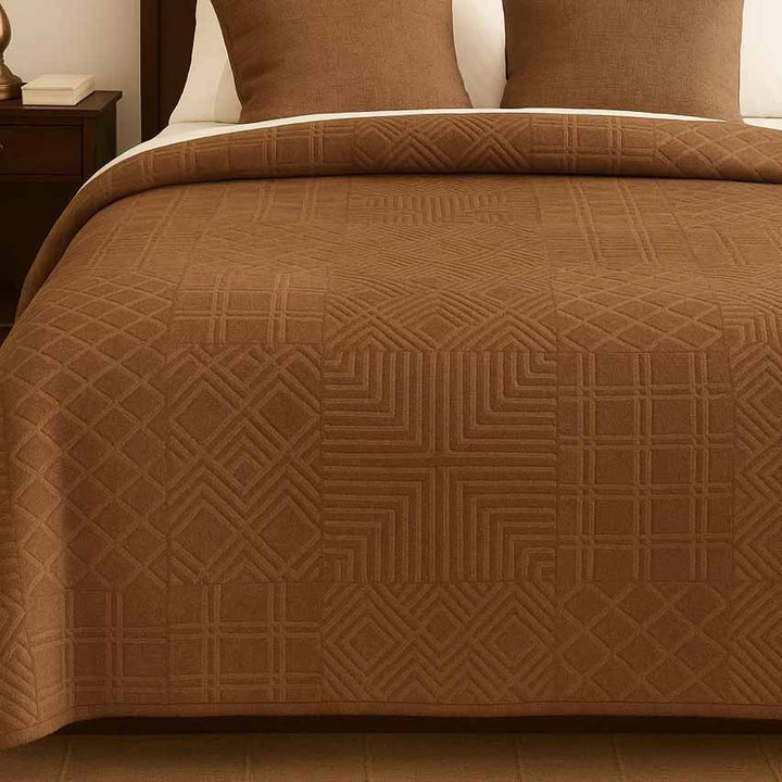 Brown winter blanket with a geometric pattern on a bed