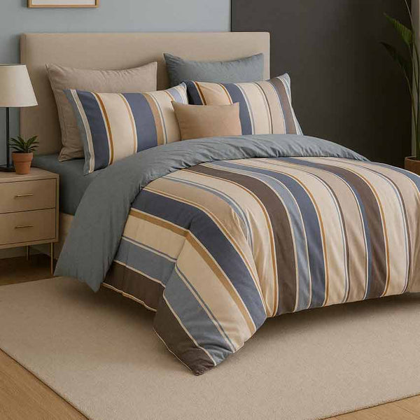 Striped bedding set on a bed with a nightstand and lamp in a bedroom setting.