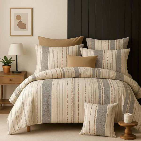 Striped bedding set on a bed with matching pillows in a bedroom setting.