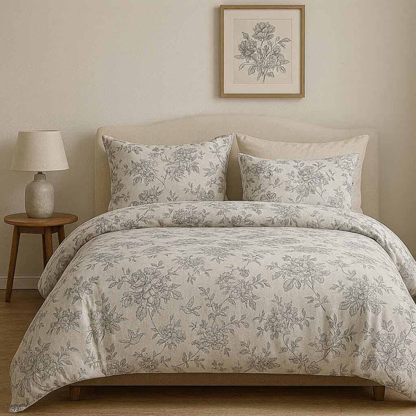 Floral patterned bedding set on a bed with a side table and lamp in a bedroom setting.