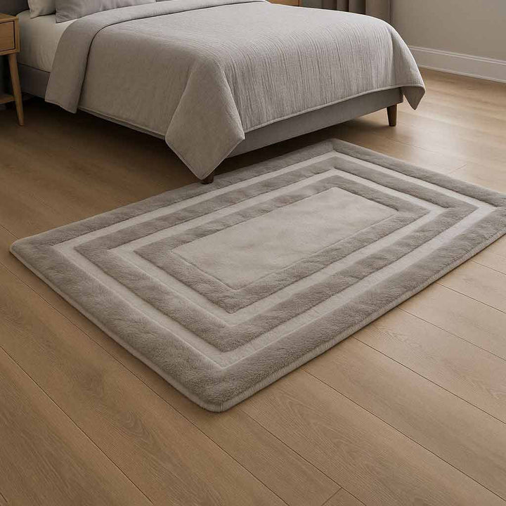 Gray area rug on a wooden floor in a bedroom setting
