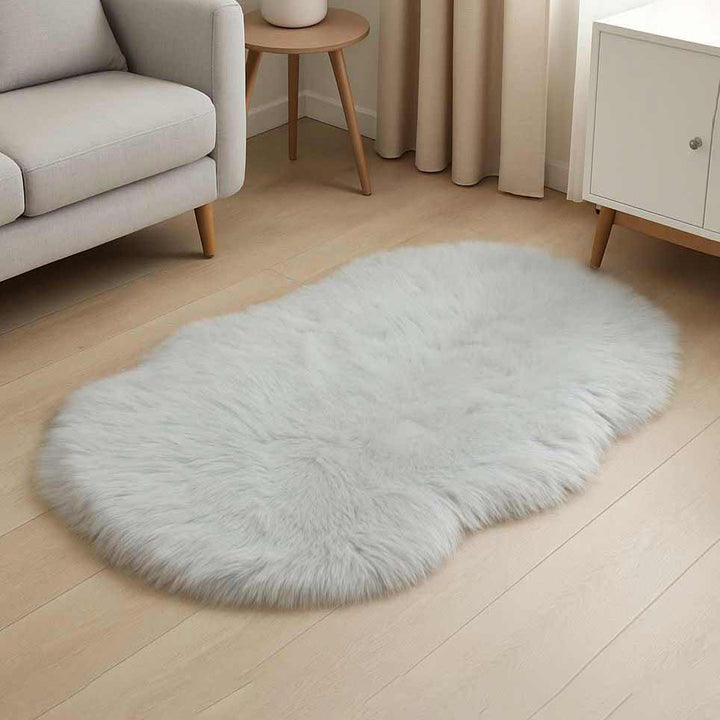 light gray fluffy rug on a wooden floor with a chair and black curtain in the background.
