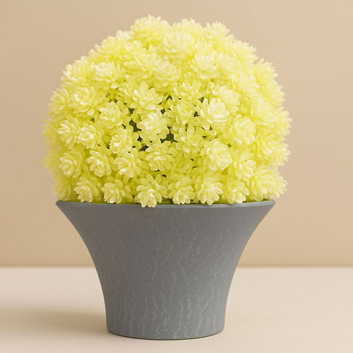 Yellow artificial flowers in a gray pot on a beige background