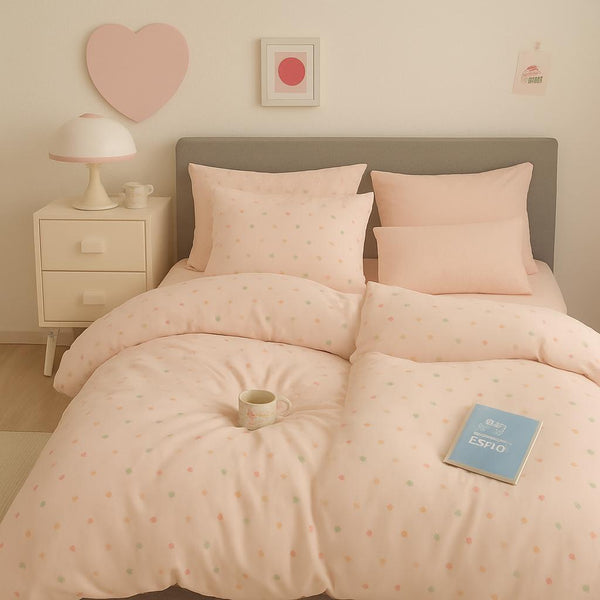 Bedroom with pink polka dot bedding, nightstand, and heart decoration.