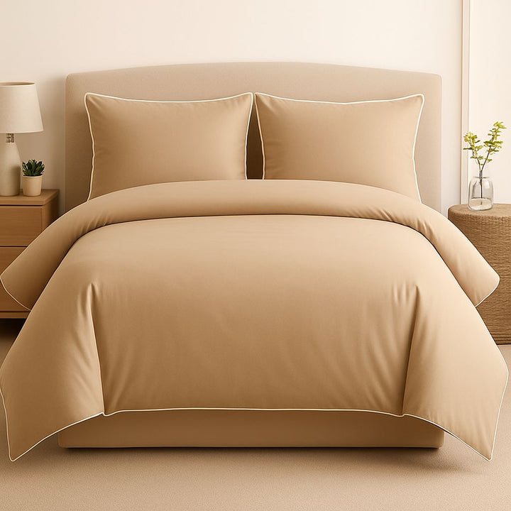 Beige bedding set on a bed with matching pillows in a bedroom setting.