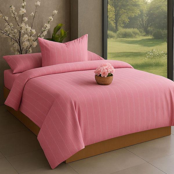 Pink striped duvet cover set on a bed with a window view of greenery.