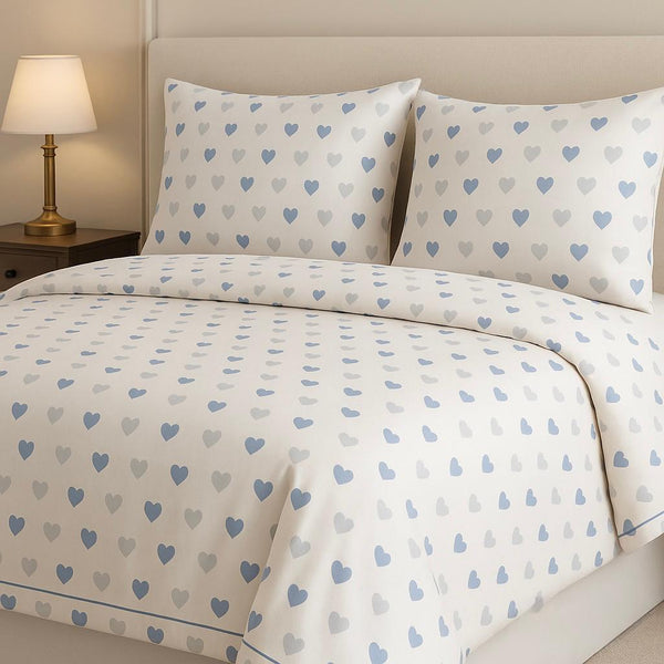 Heart-patterned bedding set on a bed with a lamp in the background
