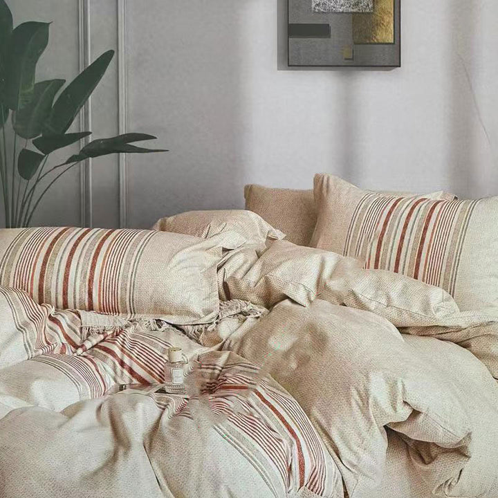 Neatly made bed with striped bedding in a bedroom setting