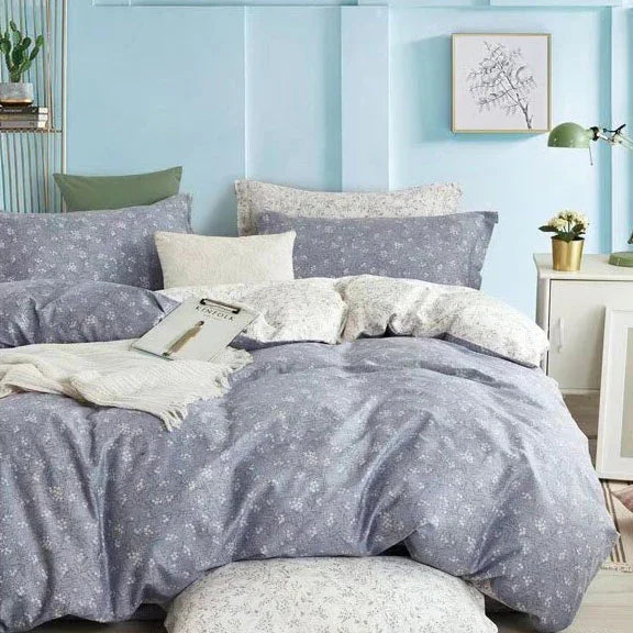 Floral patterned bedding set on a bed in a bedroom with light blue walls.
