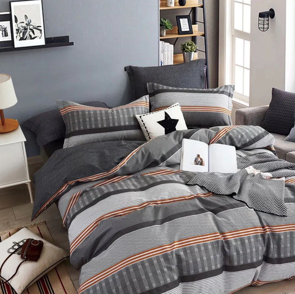 Gray and brown striped bedding set on a bed in a bedroom with a lamp and shelves in the background.