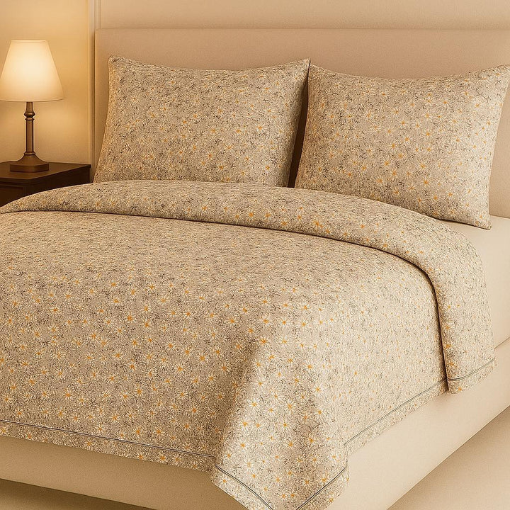 Floral patterned bedspread on a bed with matching pillows, in a warm-toned bedroom setting.