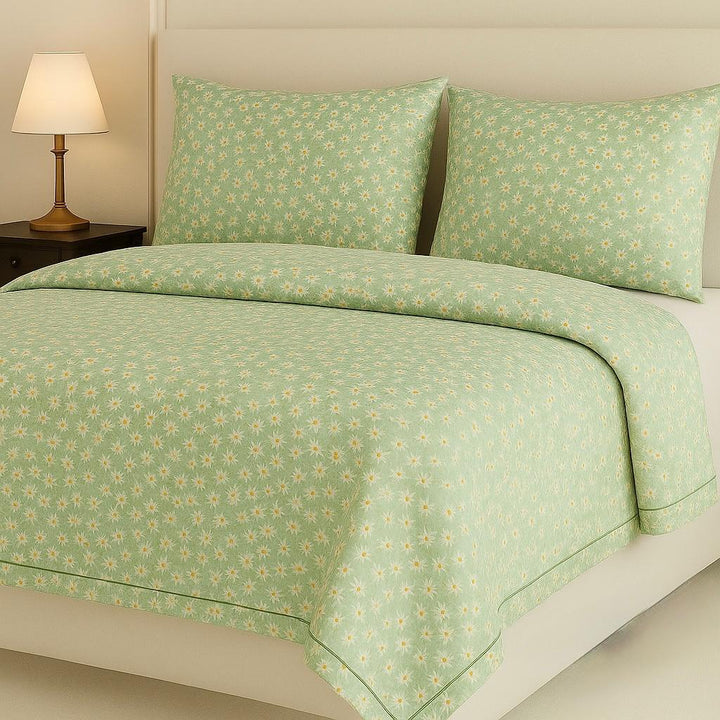 Green floral patterned bedding set on a bed in a bedroom setting.