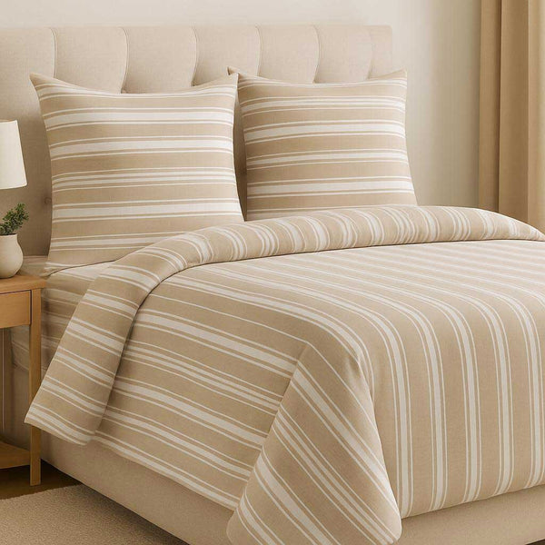 Beige and white striped bedding set on a bed with a matching headboard.