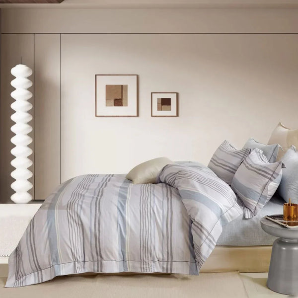 Neatly made bed with a striped bedding set in a modern bedroom setting.