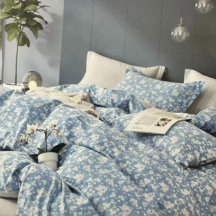 Blue floral bedding set on a bed with a gray headboard and decorative elements.