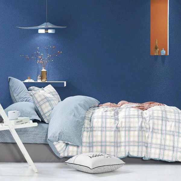 Bedroom with blue walls, bed with a plaid bedding set