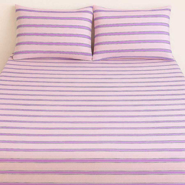Purple and pink striped sheet set on a bed.