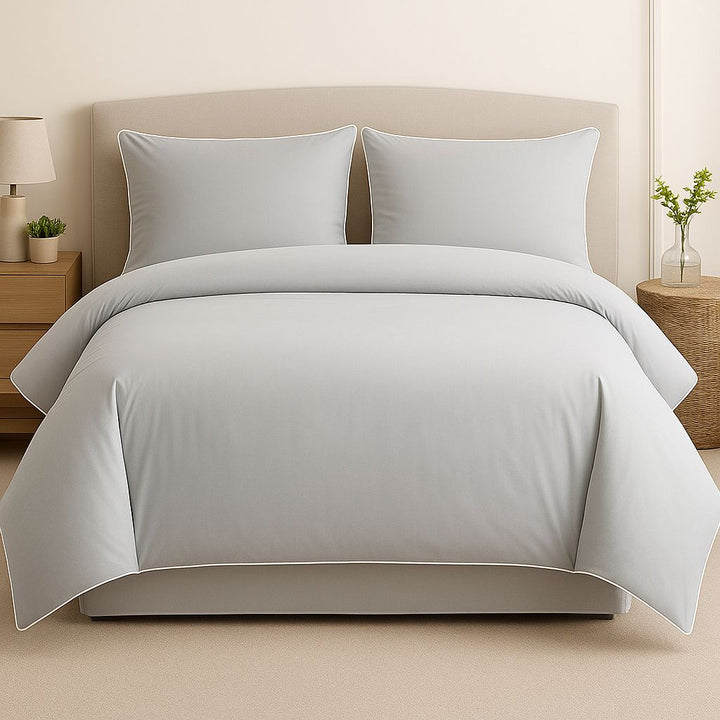 Gray bedding set on a bed with matching pillows in a bedroom setting.