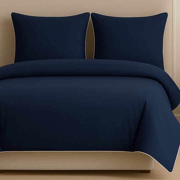 Navy blue bedding set on a bed in a bedroom setting
