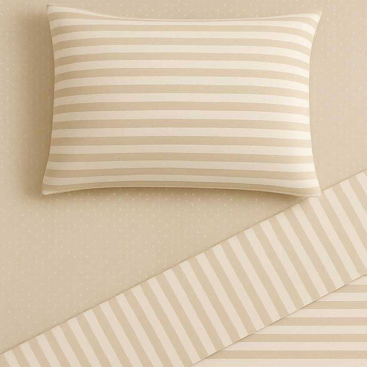 Beige striped pillow and bedding on a beige background
