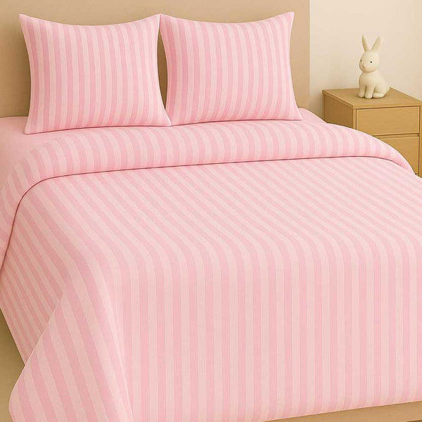 Pink striped bedding set on a bed with a nightstand and decorative item in the background.