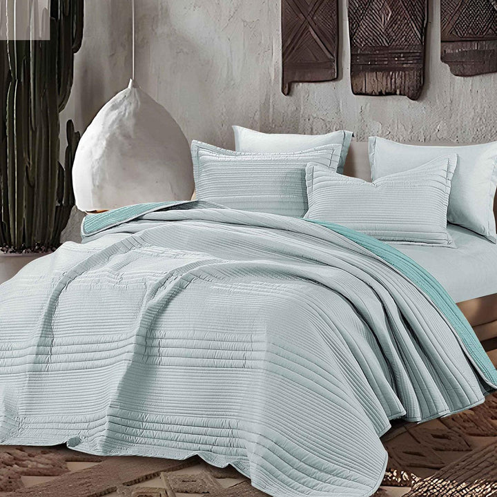 Summer baby blue bedspread set with quilted stripes pattern, styled on a made bed