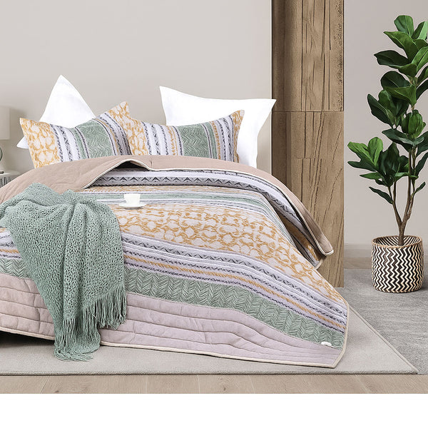 Colorful summer bedspread with striped patterns in green, yellow, lavender, and beige, styled with matching pillow shams and a soft knit throw in a modern bedroom
