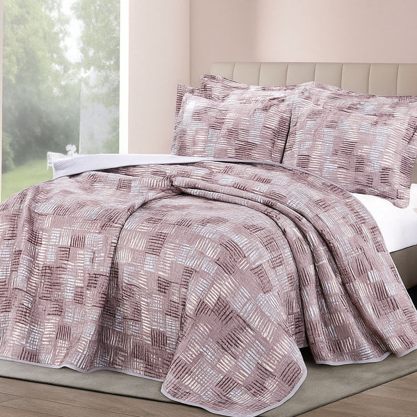 Mosaic-inspired summer bedspread in mauve and silver tones with a textured square pattern, paired with matching shams in a soft daylight bedroom