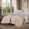 Summer beige bedspread set with quilted wavy lines pattern, styled on a made bed