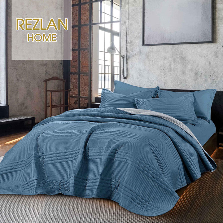 Summer blue bedspread set with quilted stripes pattern, styled on a made bed