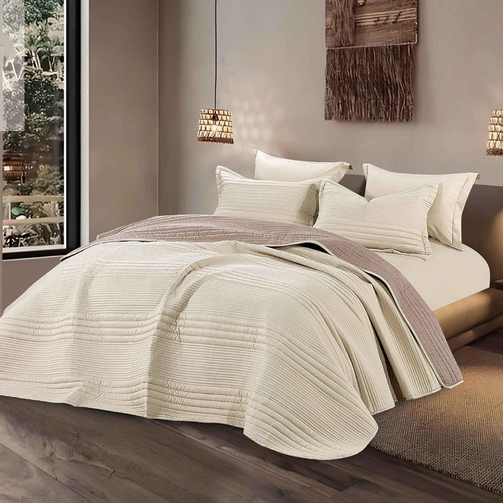 Summer greige bedspread set with quilted stripes pattern, styled on a made bed