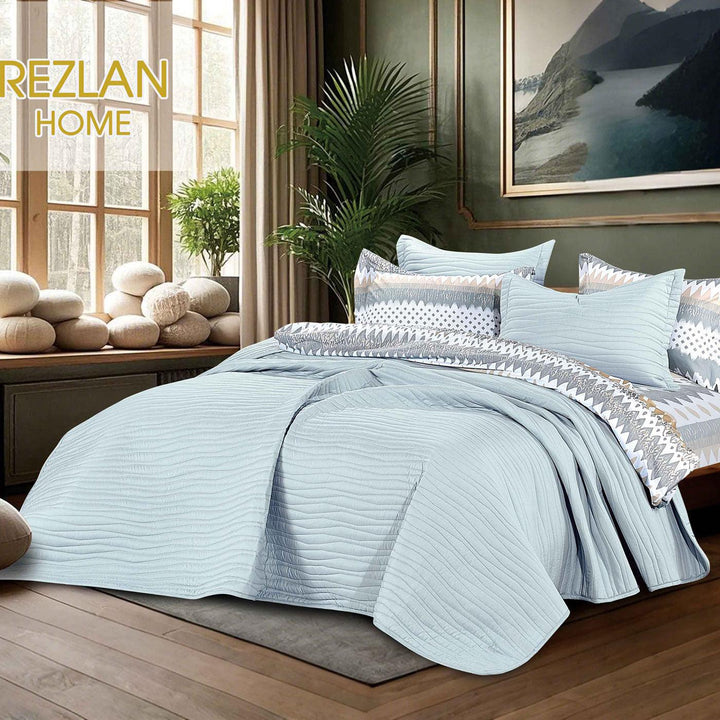 Summer light blue bedspread set with quilted wavy lines pattern, styled on a made bed
