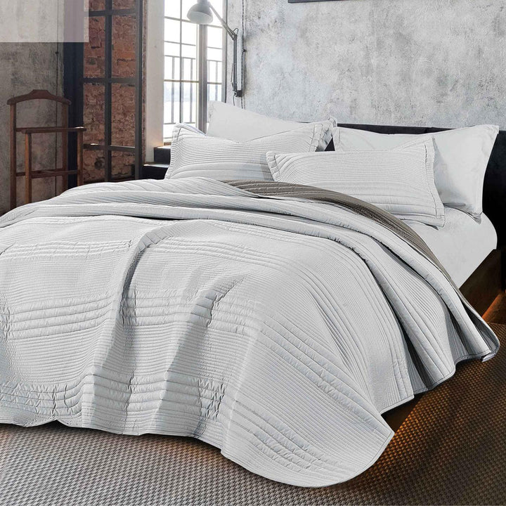Summer light gray bedspread set with quilted stripes pattern, styled on a made bed