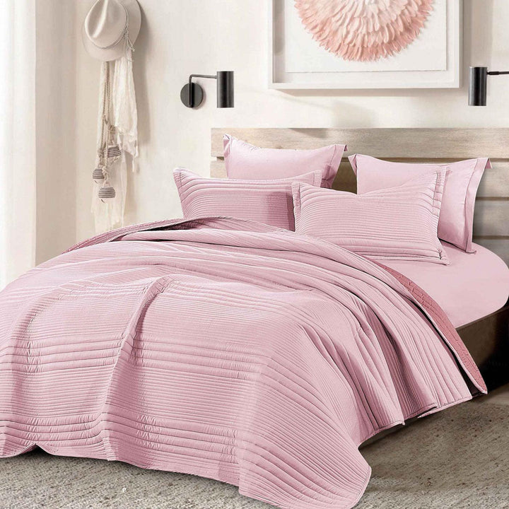 Summer pink bedspread set with quilted stripes pattern, styled on a made bed
