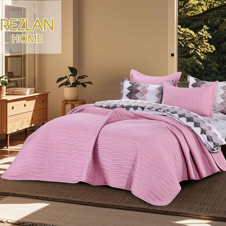 Summer pink bedspread set with quilted wavy lines pattern, styled on a made bed