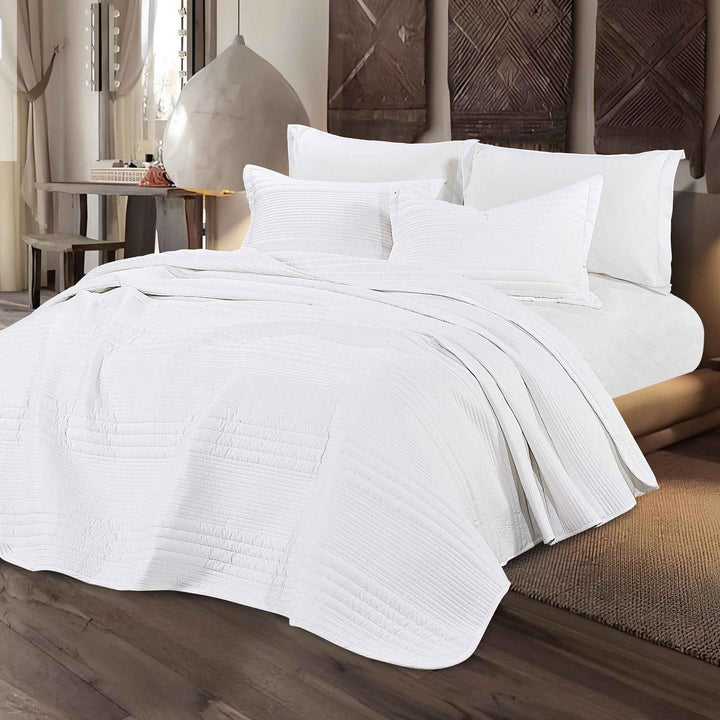 Summer white bedspread set with quilted stripes pattern, styled on a made bed