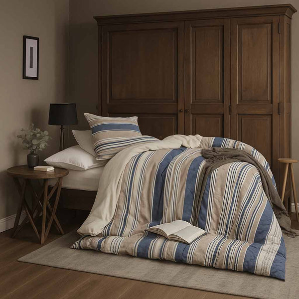 Bed with striped bedding and pillows in a bedroom setting.