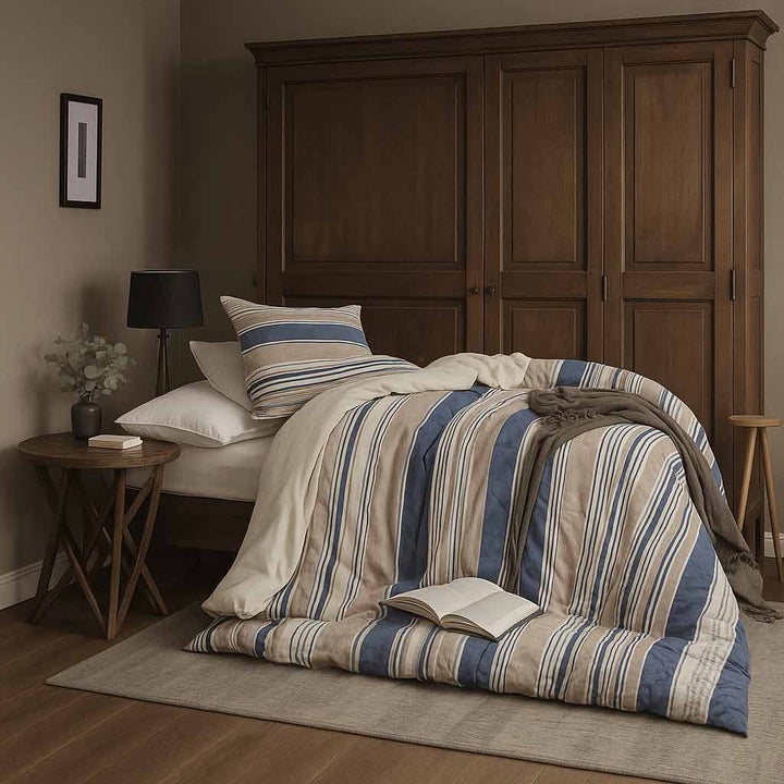 Bed with striped bedding and pillows in a bedroom setting.