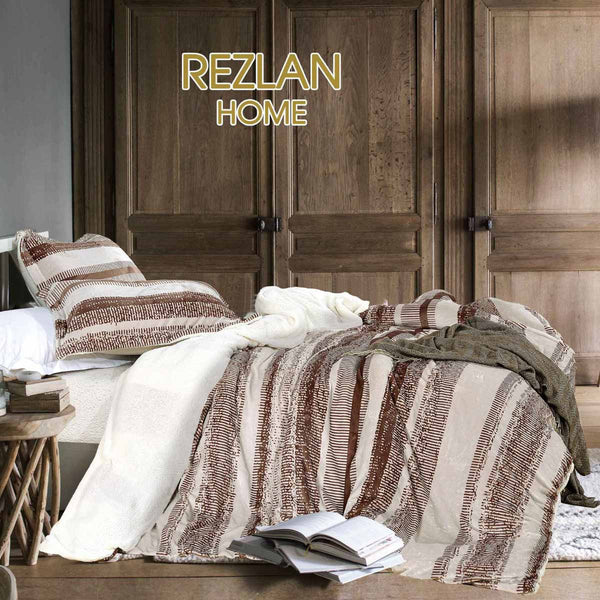 Bed with striped bedding and a book, against a wooden wardrobe, featuring 'Rezlan Home' branding.
