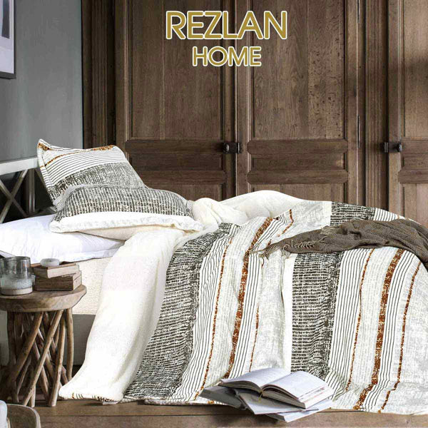 Bed with striped bedding and pillows in a bedroom setting, featuring 'Rezlan Home' branding.