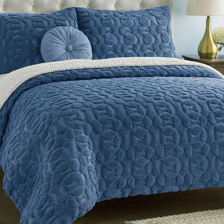 Blue textured duvet cover set on a bed with matching pillows.