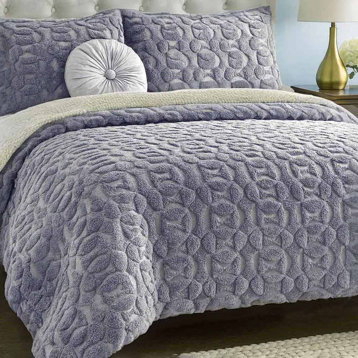 Textured gray duvet cover set on a bed with matching pillows in a bedroom setting.