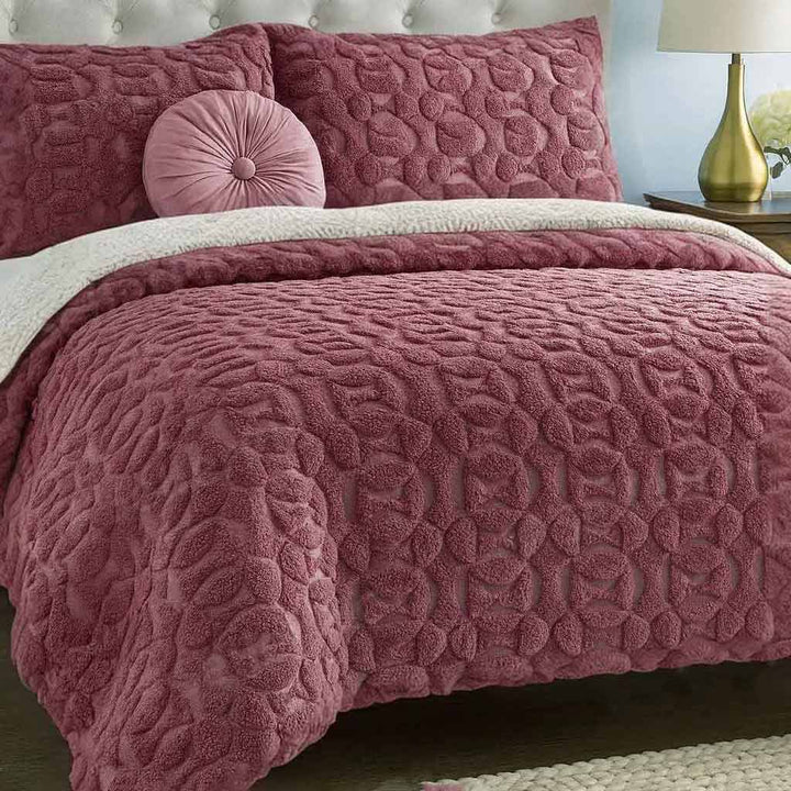 Pink textured quilted duvet cover set on a bed with matching pillows.